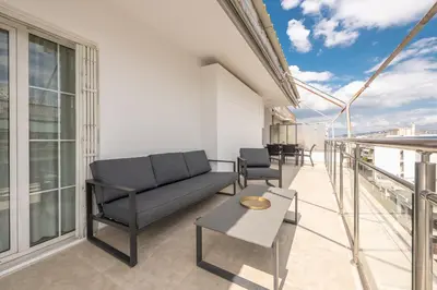 a living room with a couch and chairs on a balcony at Athens Del Sol Suite in Athens