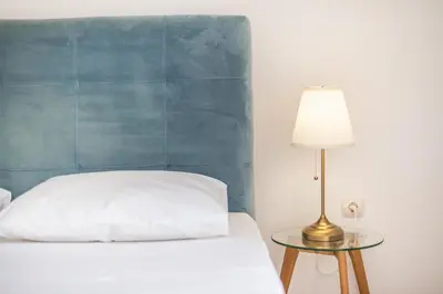 a bedroom with a bed and a table with a lamp at Athens Del Sol Suite in Athens