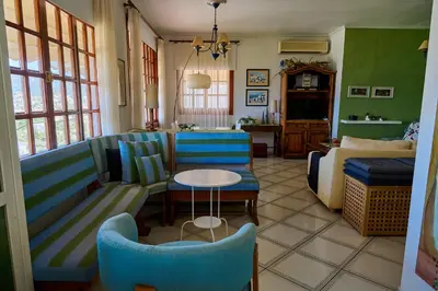 a living room with a couch and a table and a bed at The Captain's Penthouse in Porto Rafti