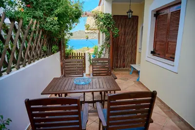 a wooden table and chairs on a patio at The Captain's Penthouse in Porto Rafti