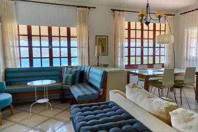 a living room with a couch and chairs and a table at The Captain's Penthouse in Porto Rafti