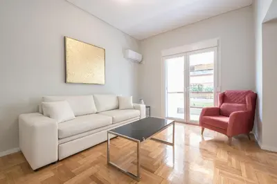 a living room with a white couch and a red chair at Victoria Divas Paradise Suite in Athens