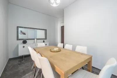 a dining room with a wooden table and white chairs at Victoria Divas Paradise Suite in Athens