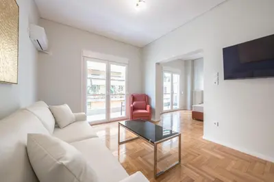 a living room with a white couch and a table at Victoria Divas Paradise Suite in Athens