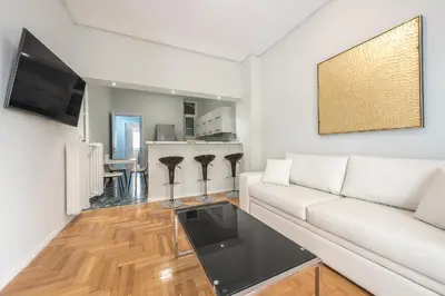a living room with a white couch and a table at Victoria Divas Paradise Suite in Athens
