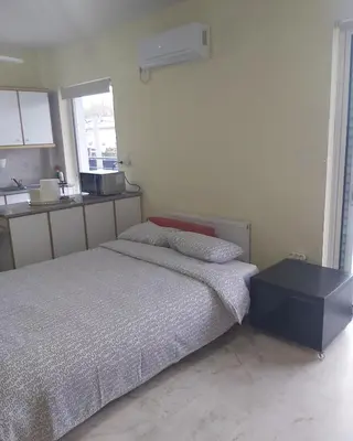a bedroom with a bed and a table in it at Daisy luxury in Piraeus