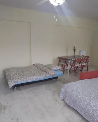 a room with two beds and a table with a table at Daisy luxury in Piraeus