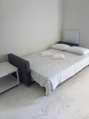 a bedroom with a bed with a table and a chair at Daisy luxury in Piraeus