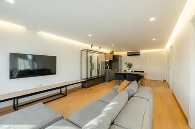 a living room with a couch and a tv at Earth Boutique Apartments next to Stavros Niarchos in Athens