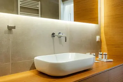 a bathroom with a white sink on a wooden counter at Earth Boutique Apartments next to Stavros Niarchos in Athens