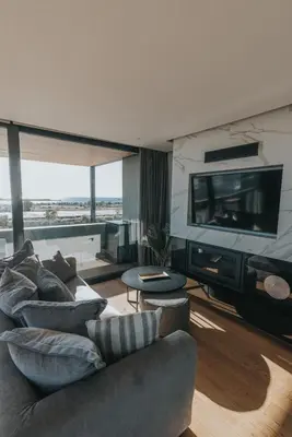 a living room with a couch and a flat screen tv at Earth Boutique Apartments next to Stavros Niarchos in Athens