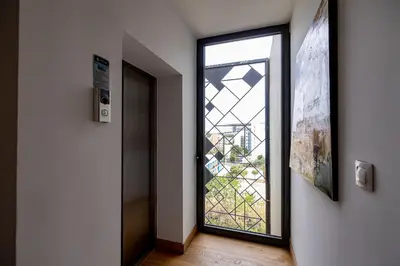a door with a glass window in a hallway at Earth Boutique Apartments next to Stavros Niarchos in Athens