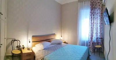 a bedroom with a bed with a blue comforter and a window at The Traditional Athenian house for 6, near metro in Athens