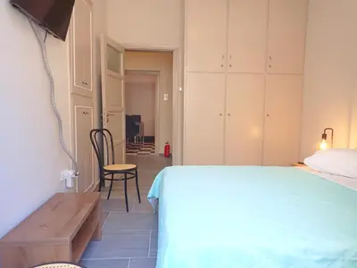 a bedroom with a bed and a table and a chair at The Traditional Athenian house for 6, near metro in Athens
