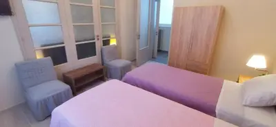 a bedroom with two beds and two chairs and a window at The Traditional Athenian house for 6, near metro in Athens