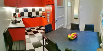 a kitchen with red cabinets and a bowl of fruit on a table at The Traditional Athenian house for 6, near metro in Athens