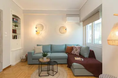 a living room with a blue couch and a table at Spacious 2 Bedroom Apartment In Koukaki in Athens