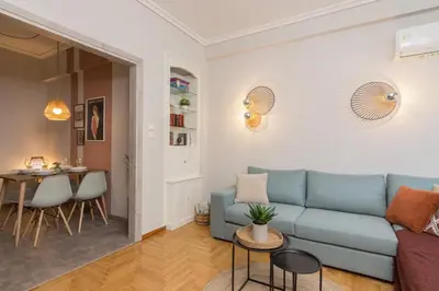 a living room with a blue couch and a table at Spacious 2 Bedroom Apartment In Koukaki in Athens