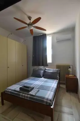 a bedroom with a bed with a ceiling fan at Agia Marina apartment in Aghia Marina