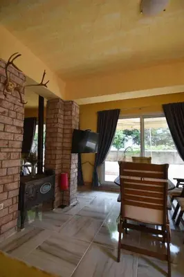 a living room with a fireplace and a table and chairs at Agia Marina apartment in Aghia Marina