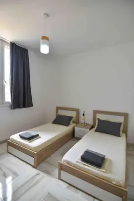a room with two beds and a window at Agia Marina apartment in Aghia Marina