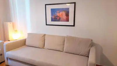 a white couch in a living room with a picture on the wall at Cozy apartment in Plaka in Athens