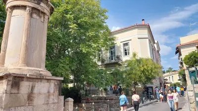 a group of people walking down a street in front of a building at Cozy apartment in Plaka in Athens
