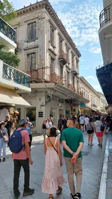 a group of people walking down a city street at Cozy apartment in Plaka in Athens