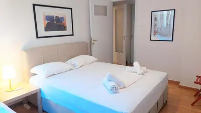 a bedroom with a white bed with two pillows at Cozy apartment in Plaka in Athens