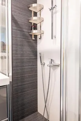a bathroom with a shower with a shower head at Kolonaki Comfort, Walk to Metro, Plaka & Syntagma in Athens