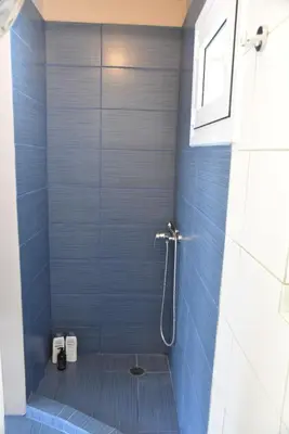 a bathroom with a shower with blue tiles at Athens Tiny rooftop by Super Host Hub in Athens