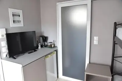 a room with a desk with a television and a mirror at Athens Tiny rooftop by Super Host Hub in Athens