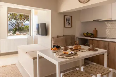 a kitchen with a white table with fruit on it at Casa Meraki by A&D Properties in Porto Rafti