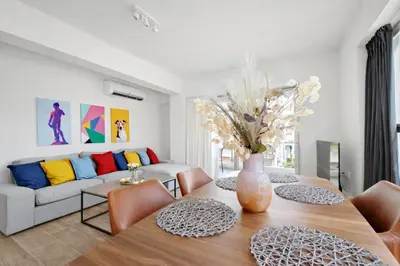 a living room with a table and a couch at Costa Alimos by Verde Apartments in Athens