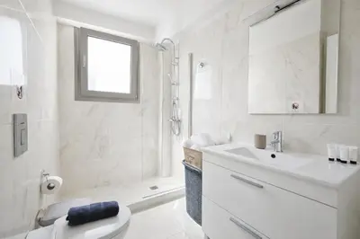 a white bathroom with a toilet and a sink at Costa Alimos by Verde Apartments in Athens