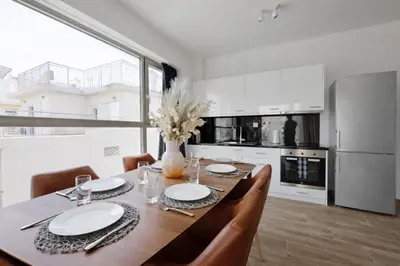 a dining room with a table and chairs and a kitchen at Costa Alimos by Verde Apartments in Athens