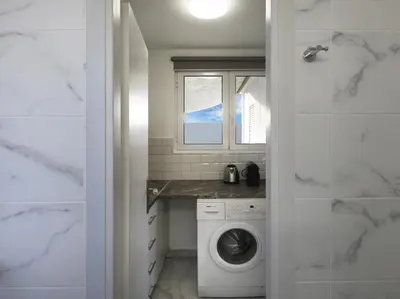 a laundry room with a washing machine and a window at Acropolis View top floor apartment in Athens