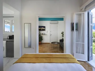 a bedroom with a large bed and a kitchen at Acropolis View top floor apartment in Athens