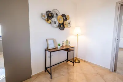 a room with a table and a heart plate on the wall at Thea Apartment_Athens Airport in Spáta
