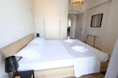 a bedroom with a white bed with two white dishes on it at Thea Apartment_Athens Airport in Spáta