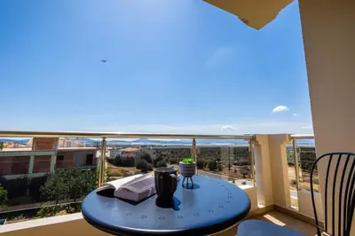 a table on a balcony with a view at Thea Apartment_Athens Airport in Spáta