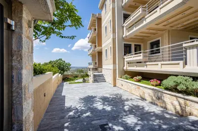 a house with a walkway leading to a building at Thea Apartment_Athens Airport in Spáta
