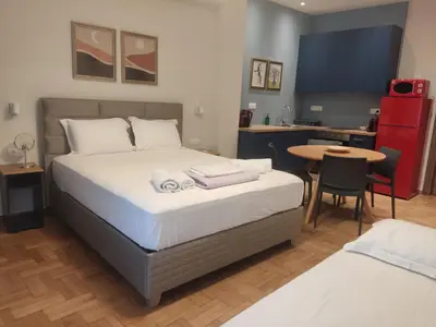 a bedroom with a bed and a table and a kitchen at Acropolis Oasis by YHA in Athens