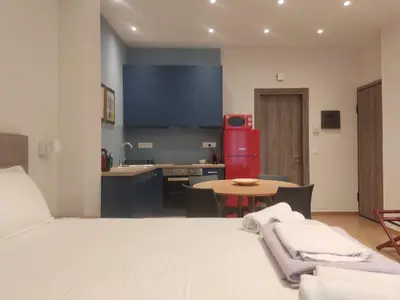 a room with a bed and a kitchen with a table at Acropolis Oasis by YHA in Athens