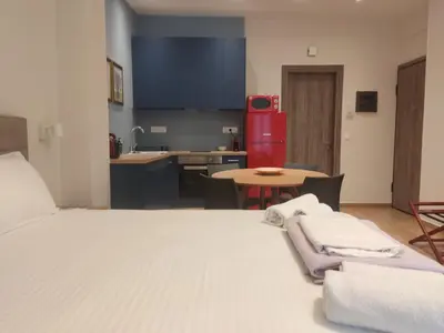 a room with a bed and a kitchen with a table at Acropolis Oasis by YHA in Athens