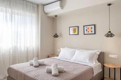 a white bedroom with a large bed with white pillows at Divine 2BR Apartment in the Heart of Athens in Athens