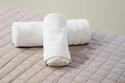two rolls of white towels on a bed at Divine 2BR Apartment in the Heart of Athens in Athens