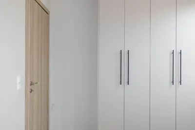 a row of white cabinets next to a door at Divine 2BR Apartment in the Heart of Athens in Athens