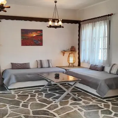 a living room with two beds and a table at Sylvia's house at Vagia in Vaia