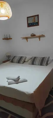 a bedroom with a bed with white sheets and a lamp at Sylvia's house at Vagia in Vaia